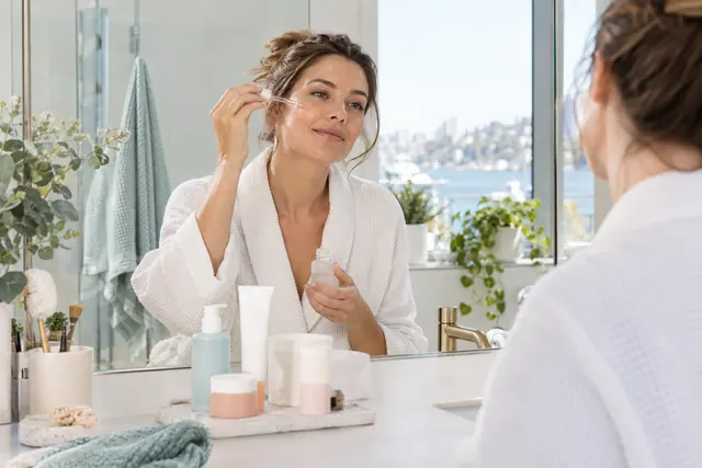 Illustrative skincare routine at a bathroom mirror; not a product test.